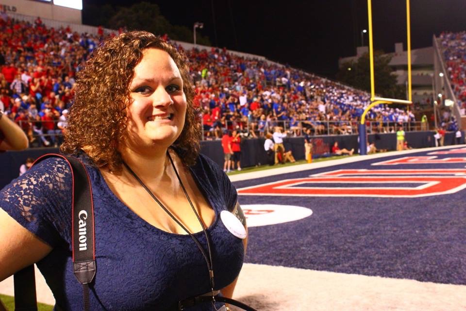A woman with curly hair on a football field